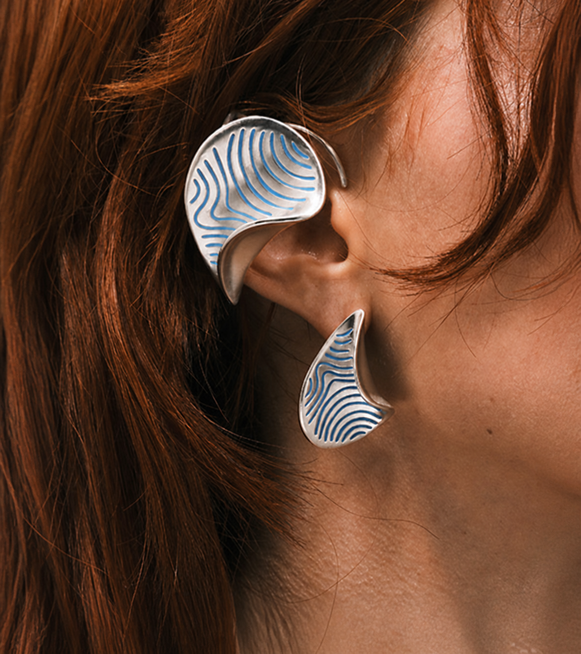 FOLD Earrings in sterling silver shown on the ear with a matching cuff