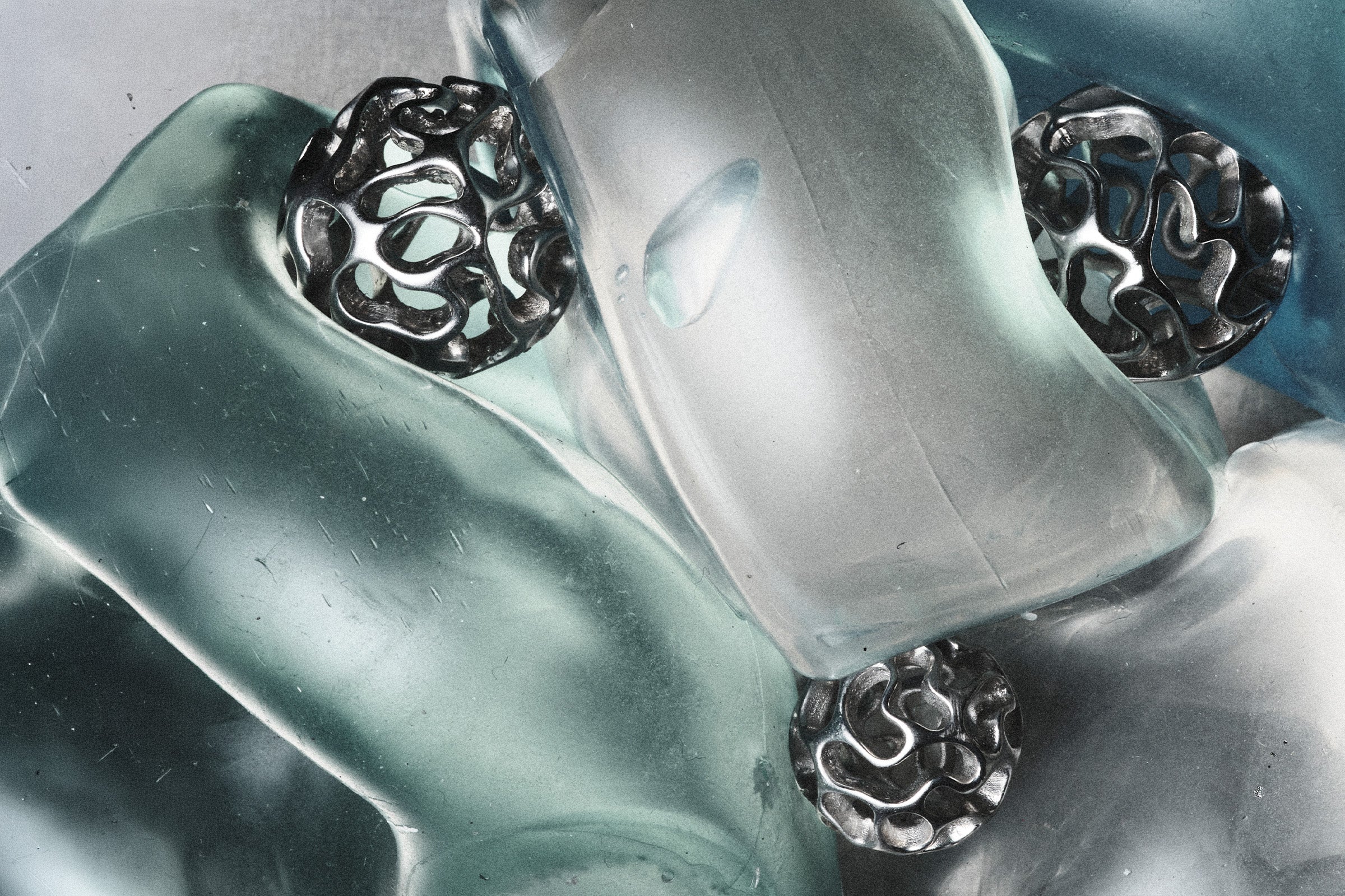 Sculptural silver AION forms among translucent glass shapes