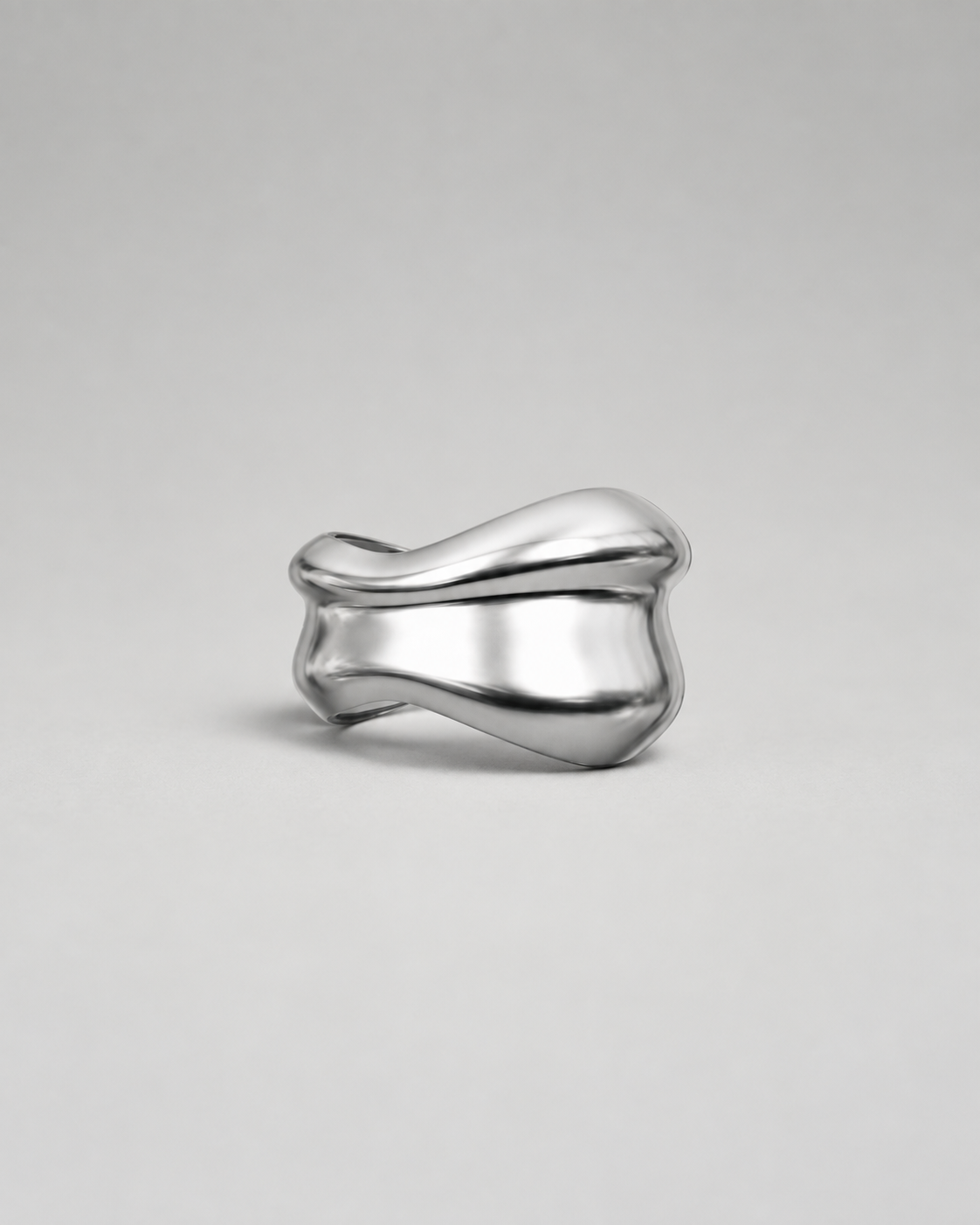 UNDULA silver bangle against a soft gray studio background